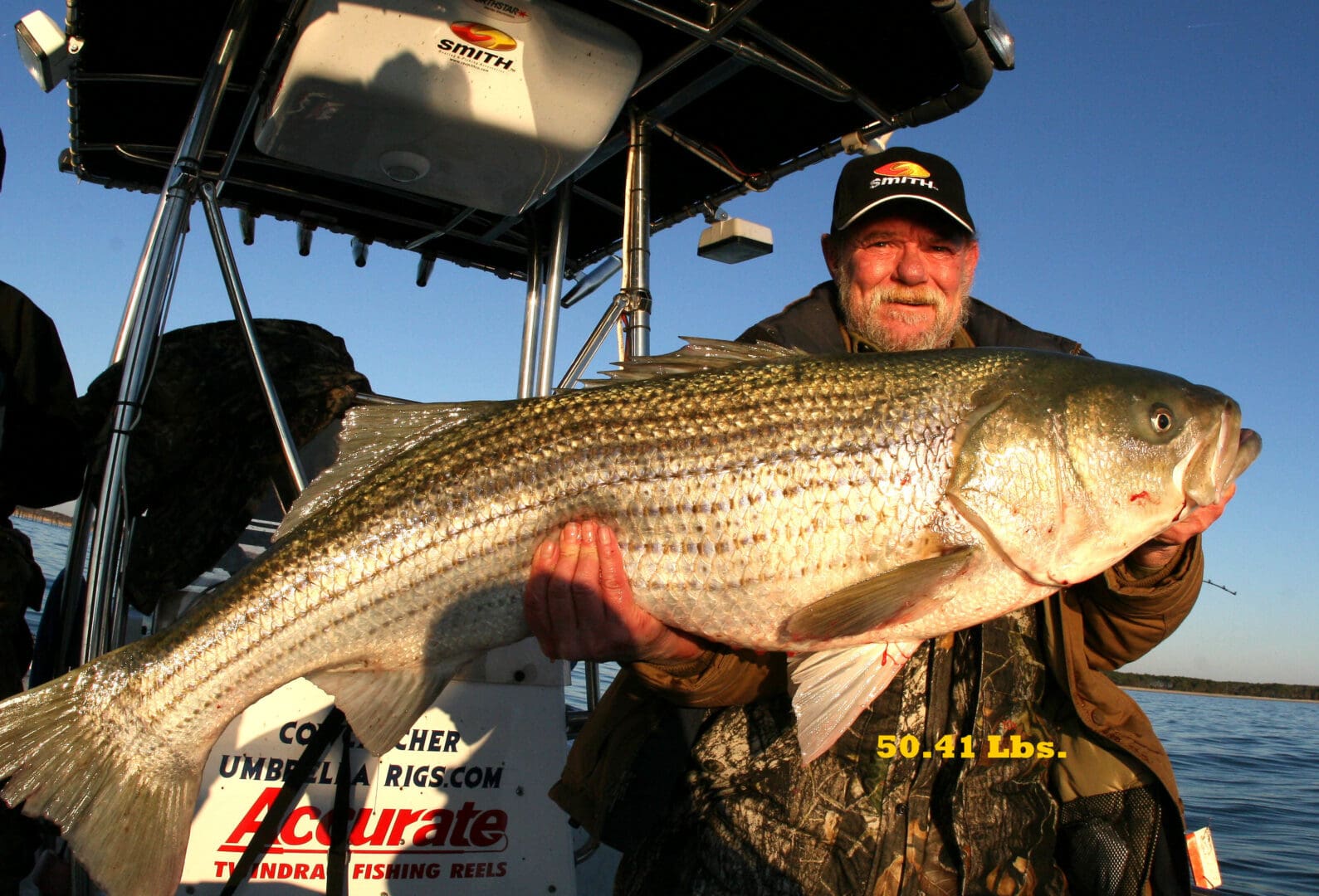 A man holding a large fish on top of a boat.