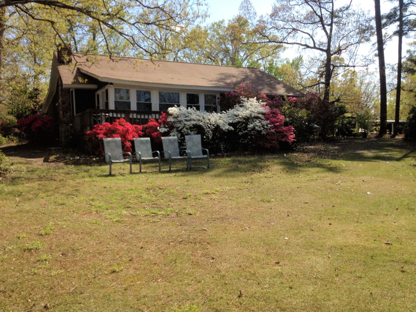 A house with several lawn chairs in front of it.