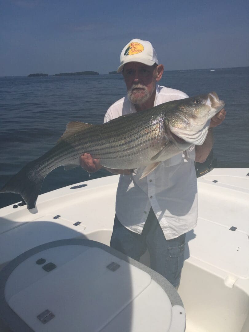 A man holding a large fish on top of a boat.